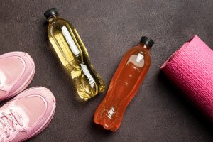 doua sticle de electroliti langa echipament de sport