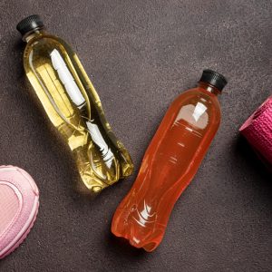 doua sticle de electroliti langa echipament de sport